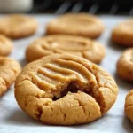 Close-up of thick and chewy peanut butter cookie showing soft cookies interior and classic fork marks